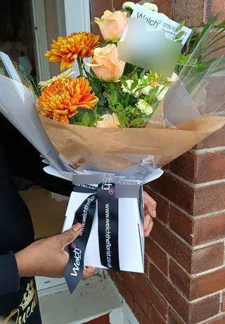 Peach roses and orange chrysanthemums in Welch wrapping