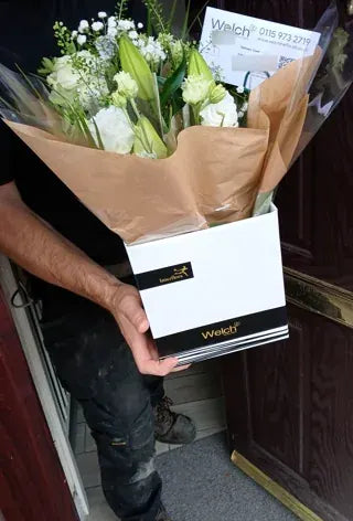 White flowers and lily buds in a Welch gift box