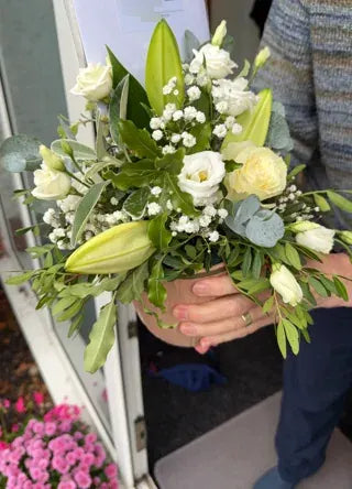White roses and lily buds in a small arrangement