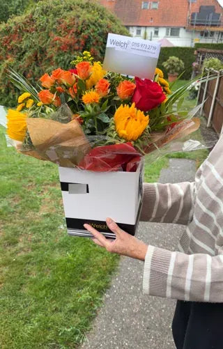 Sunflowers and orange roses in a Welch gift box