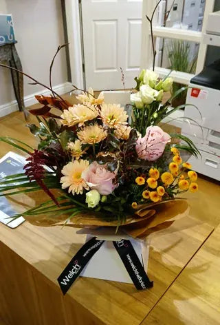 Seasonal flowers in a Welch ribbon carrier