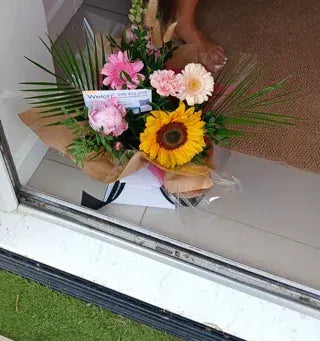 A mixed bouquet with a sunflower at a doorway
