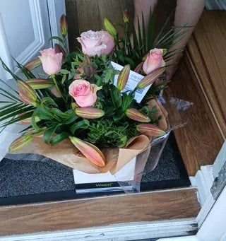 Pink roses and lily buds at a doorstep