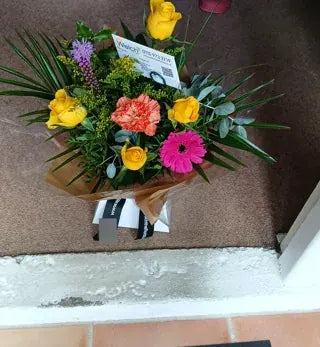 Yellow roses and a pink gerbera in Welch wrapping
