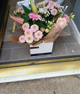 Pink chrysanthemums and lilies in Welch wrapping