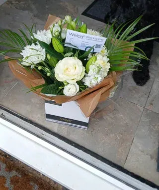 White flowers and lily buds at a doorstep