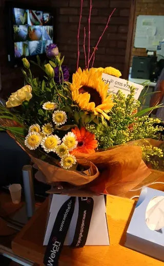 Sunflowers and white daisies in Welch ribbon wrapping