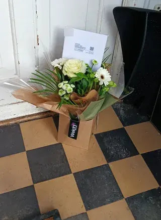 White flowers in a small Welch kraft carrier