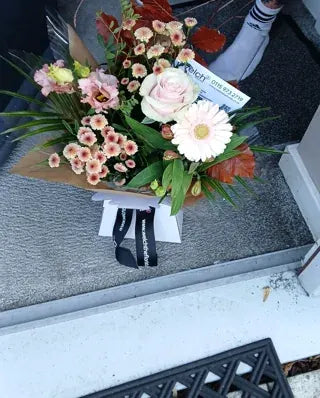 Pale pink roses and gerbera in Welch ribbon wrapping