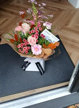 Pink roses and snapdragons in Welch ribbon wrapping