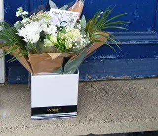 White flowers delivered to a blue front door