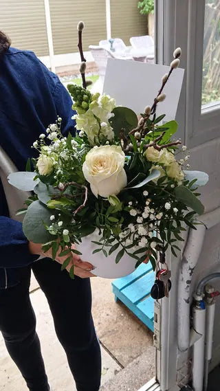 White rose arrangement with eucalyptus and pussy willow in a white jug