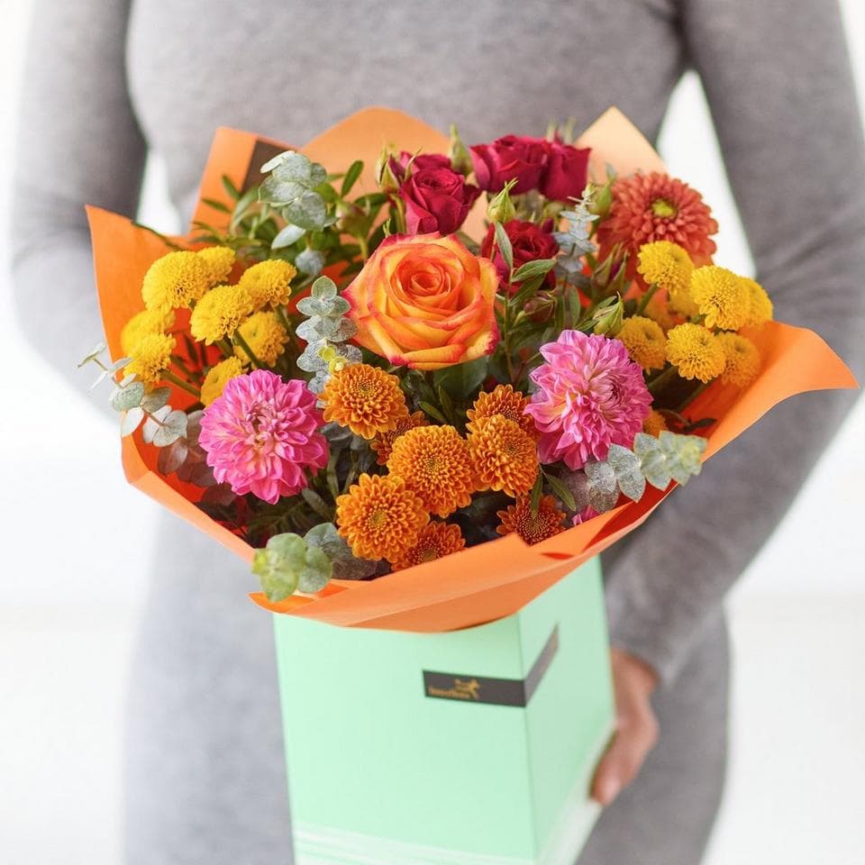 Bright and colourful flower bouquet with roses, dahlias, and marigolds in a gift box. The Dahlia Delight, an Autumn Bouquet from Welch the Florist | Next Day Flower Delivery UK Florist.