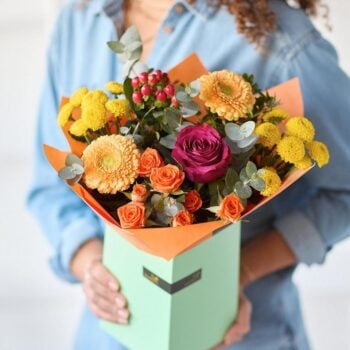 Colourful flower bouquet with roses, chrysanthemums, and berries in a green wrapping. The Autumn Rainbow, an Autumn Bouquet from Welch the Florist | Next Day Flower Delivery UK Florist.