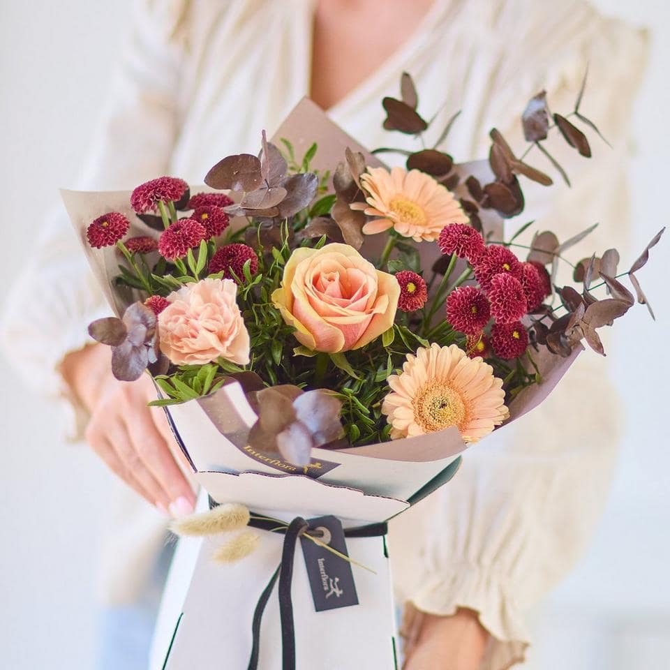 Beautiful mixed flower bouquet with roses, gerbera daisies, and eucalyptus leaves. The Dawn Garden, an Autumn Bouquet from Welch the Florist | Next Day Flower Delivery UK Florist.